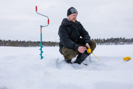Ice Fishing on the frozen Tornetrask Lake in Abisko
